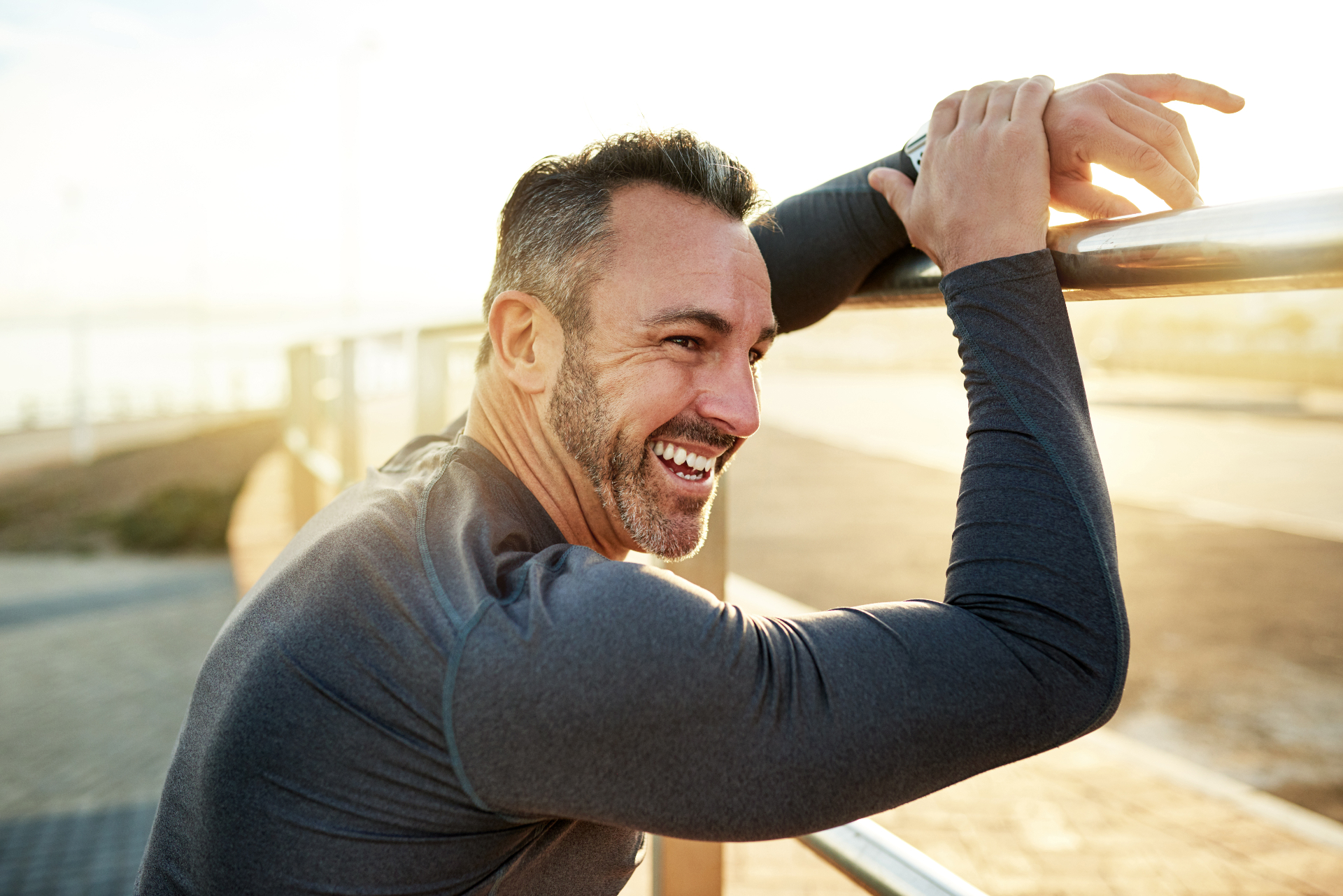 Smiling man leaning on a railing after a workout